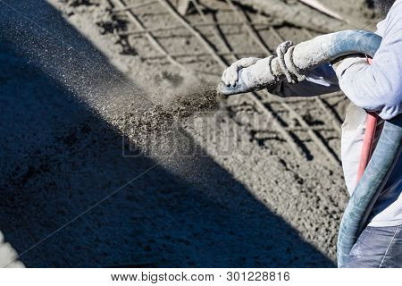 Pool Construction Worker Shooting Concrete, Shotcrete or Gunite Through Hose