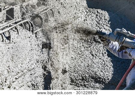 Pool Construction Worker Shooting Concrete, Shotcrete or Gunite Through Hose