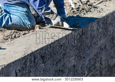 Pool Construction Worker Working With Wood Float On Wet Concrete