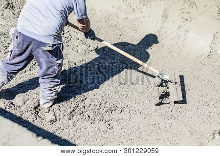 Pool Construction Worker Working With A Bullfloat On Wet Concrete