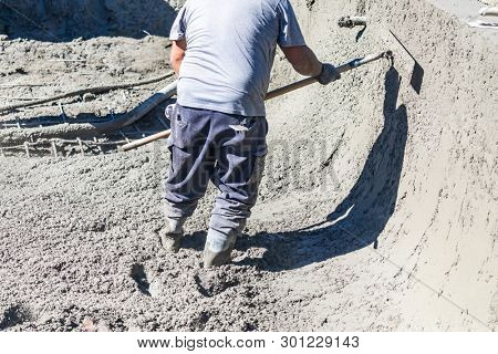 Pool Construction Worker Working With A Bullfloat On Wet Concrete