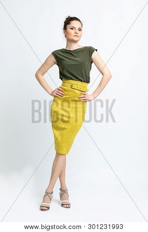Model In Green Blouse, Yellow Suede Skirt With Yellow Belt, White Heeled Sandals Isolated On White B