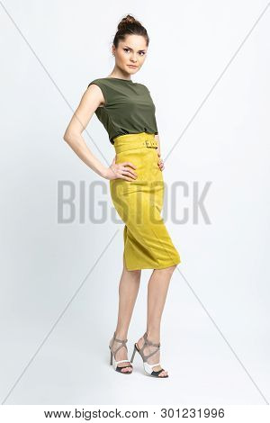 Model In Green Blouse, Yellow Suede Skirt With Yellow Belt, White Heeled Sandals Isolated On White B