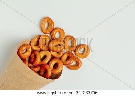 Drying Or Bagels Spilled Out Of A Paper Bag On A White Background, Plenty Of Space For Text. Bright 