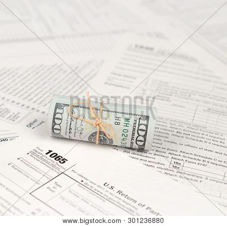 1065 U.s. Return Of Parentship Income Form With Roll Of American Dollar Banknotes