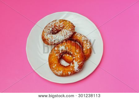 Appetizing Donuts With Icing Sugar On A White Plate On A Pink  Background, Plenty Of Space For Text,