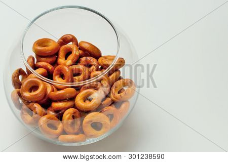 Drying Or Bagels In A Glass Round Vase On A White Background, Plenty Of Space For Text, Bright Color