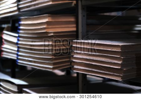 Lurred Background With Bookshelves In The Library. Dark Old Archive Room. Close-up. Retro Vintage St