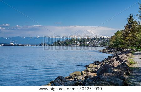 Majestic Mount Rainier Towers Over The Ruston Shoreline Near Tacoma, Washington.