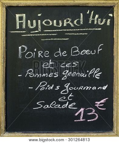 Menu Blacboard Outside A French Restaurant. In French Handwritten Is Announced What The Menu Of The 