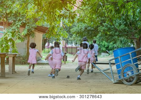 Back View Of Kindergarten Students Run Back To The Classroom After Having Lunch.