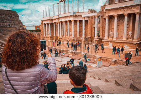 Tourist Mother And Child Taking A Picture In The Antique Roman Theatre Of Merida, Spain.