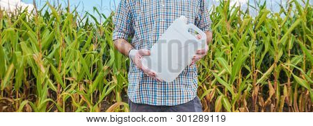 Farmer Holding Unlabeled Pesticide Jug In Field, Agronomist Recommends Herbicide For Corn Crop Prote