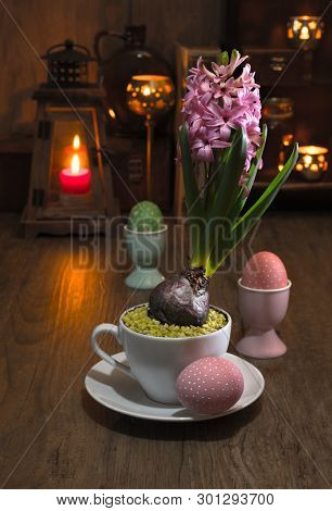 Delicate Pink Hyacinth On Vintage Kitchen With Candles And Easter Eggs