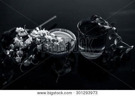 Bunch Of Flowers Of Drumstick On Wooden Surface Along With Its Extracted Water Or Tincture In A Glas