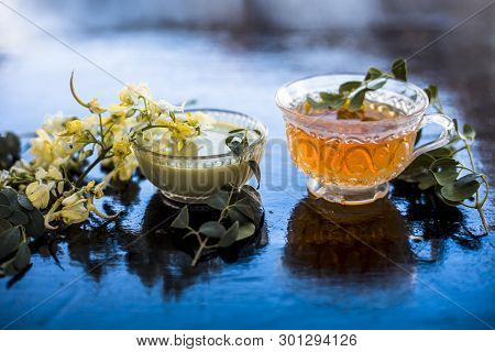 Bunch Of Flowers Of Drumstick On Wooden Surface Along With Its Extracted Tea And Paste Of Flowers In