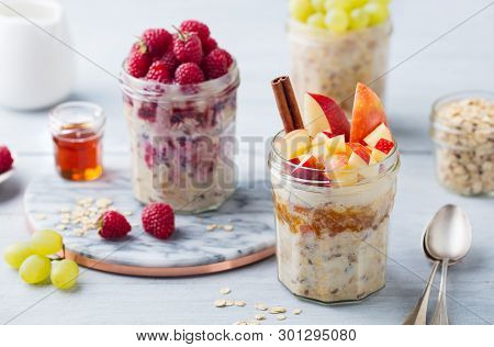 Overnight Oats, Bircher Muesli With Raspberry, Apple In Glass Jars On Wooden Background