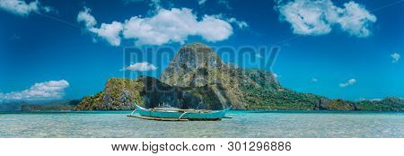 El Nido, Fishermens Boat In Blue Bay With Panoramic View Of Cadlao Island In Background, Palawan, Ph