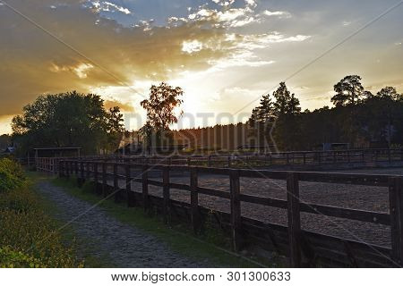 Sunset Rays Of The Sun Beautiful Against The Cloudy Sky Near The Place For Walking Horses