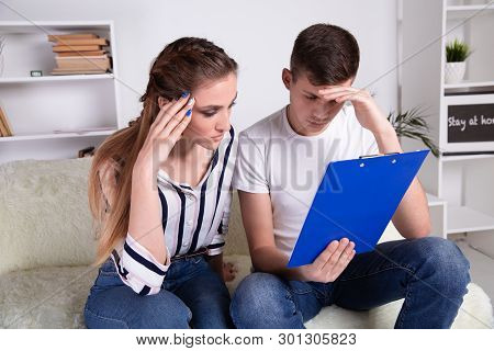 Young Caucasian Family Having Debt Problems, Not Able To Pay Out Their Loan. Female In Glasses And B