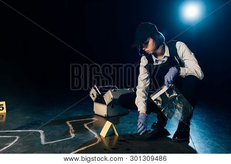 Investigator Holding Knife And Ziploc Bag At Crime Scene