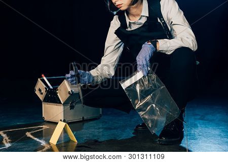 Cropped View Of Investigator Holding Knife And Ziploc Bag At Crime Scene