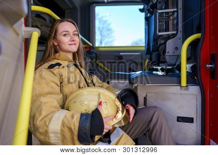 Photo of happy fire woman standing at fire truck