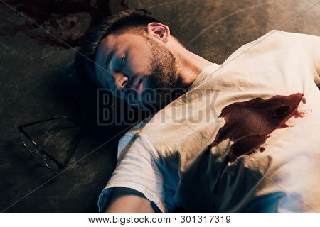 Dead Man With Blood On T-shirt On Floor At Crime Scene