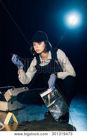 Investigator Holding Knife And Ziploc Bag At Crime Scene