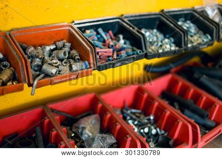 Metal, Plastic Screws, Nuts And Bolts On The Table In Car Mechanic Shop. Car Repair Equipment