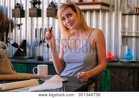 A Beautiful Freckled Blonde Girl In Pajamas Is Standing Near The Kitchen Table, Drinking Fock, Tea A