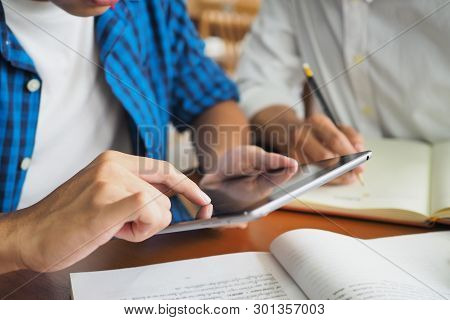 College Students Are Studying And Reading Together. Have A Touch Tablet Computer For Information.