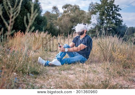 Confident Vape Man Blows Up A Couple An Electronic Cigarette. Electronic Cigarette As Alternative To