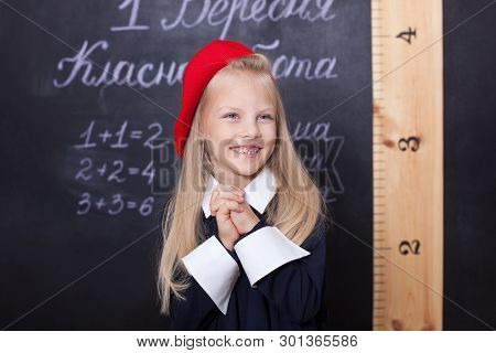 Back To School! A Schoolgirl Stands At The Blackboard With A Ruler. A Schoolgirl Answers The Lesson.