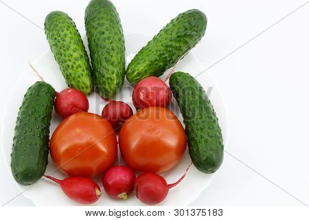 The View From The Top. Close Up. Light Background. In A Round White Plate Are Vegetables: Cucumbers,