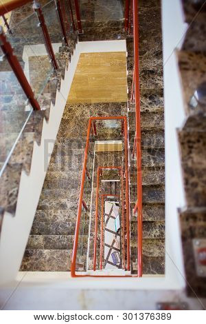 The Top View On Multystoried Ladder Flight. A Modern Marble Ladder In Office Building.