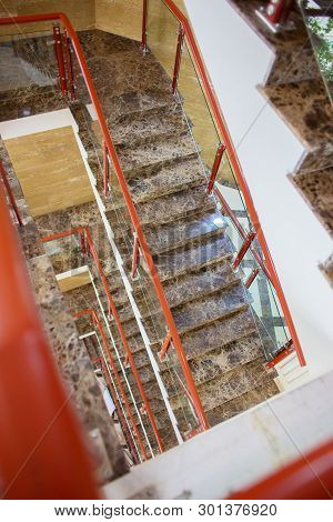 The Top View On Multystoried Ladder Flight. A Modern Marble Ladder In Office Building.