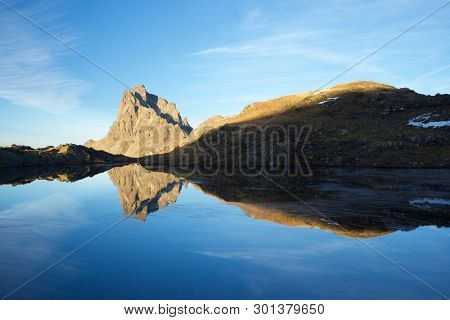 Midi Dossau Peak reflected in a lake. Ossau Valley, Pyrenees National Park, Pyrenees, France.