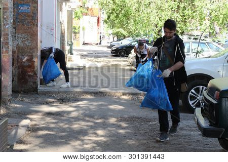Plogging. Young People Run And Collect Garbage In Bags On The Streets Of Saratov, Russia, June 10, 2