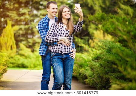 Capturing Bright Moments. Joyful Young Loving Couple Making Selfie On Camera While Standing Outdoors