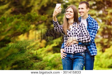 Capturing Bright Moments. Joyful Young Loving Couple Making Selfie On Camera While Standing Outdoors