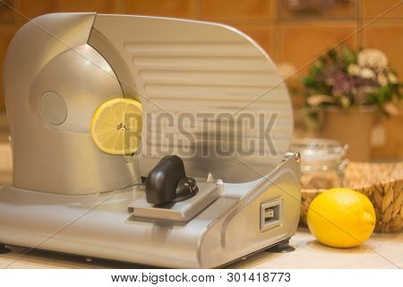 Professional Slicer For Cutting Products. A Thin Slice Of Lemon Sliced With A Slicer.