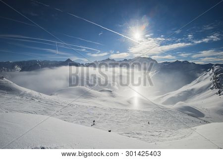 Panoramic View Down Snow Covered Valley In Alpine Mountain Range With Frost And Sunlight Sundog In A