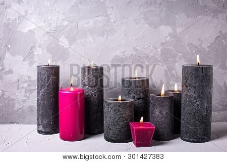 Black And Red  Burning Candles  On Grey Textured Background. Spa Or Still Life Concept. Selective Fo