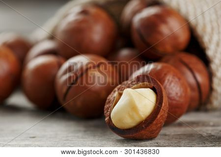 Macadamia Nut On A Wooden Table In A Bag, Closeup, Top View