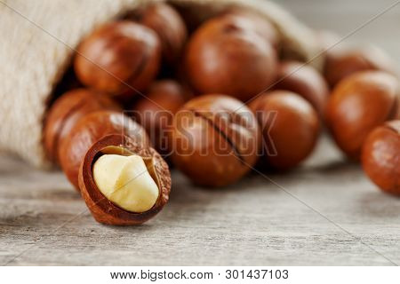 Macadamia Nut On A Wooden Table In A Bag, Closeup, Top View