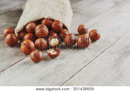 Macadamia Nut On A Wooden Table In A Bag, Closeup, Top View