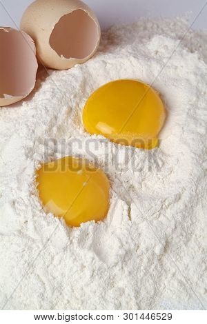 Broken Eggs Isolated Over The Flour On White Background