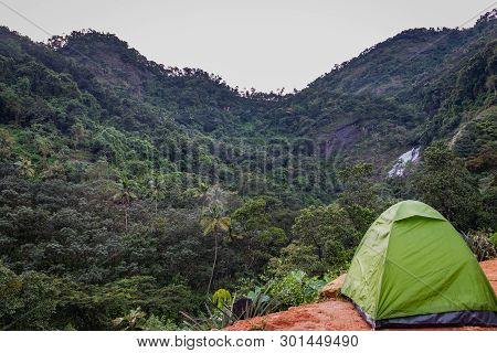 In This Image Solo Traveller Camping Experience Is Expressed With His Bike And Tent. In The Backgrou