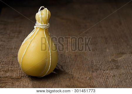 Typical Italian Cheese Caciocavallo On A Wooden Surface. Selective Focus.
